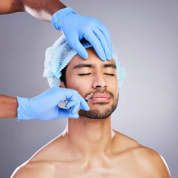 Hands, face and change with a man in studio on a gray background for a silicon injection. Beauty, plastic surgery or transformation with a male customer in a clinic for antiaging filler and cosmetics