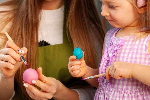 Mother and daughter coloring eggs for Easter