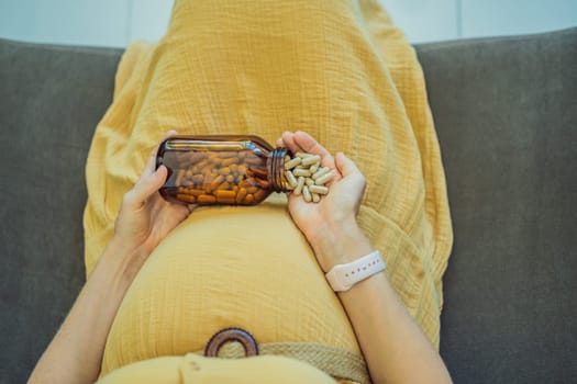 Prenatal Vitamins. Portrait Of Beautiful Smiling Pregnant Woman Holding Transparent Glass Jar With Pills, Taking Supplements For Healthy Pregnancy While Sitting On Couch At Home, Free Space