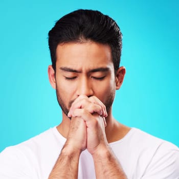 Praying, hands and man in meditation or worship to God for faith or belief in spirituality, mindfulness and peace in studio. Christian, prayer and person with religion and zen on blue background