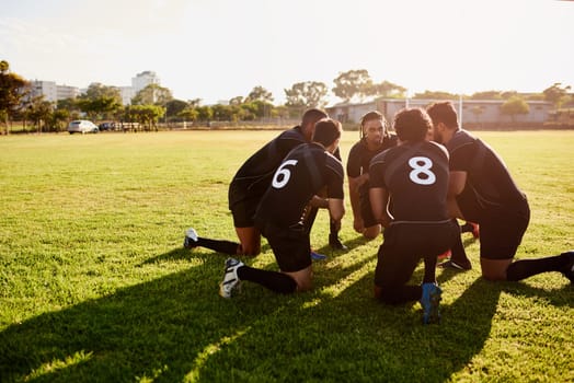 We have to win. Full length shot of a diverse group of sportsmen crouching together before playing rugby during the day.