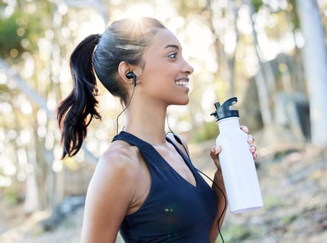 Fitness, water bottle and woman running outdoor for race, competition or marathon training. Sports, nature and female athlete runner drinking a liquid during a cardio exercise or workout in the woods