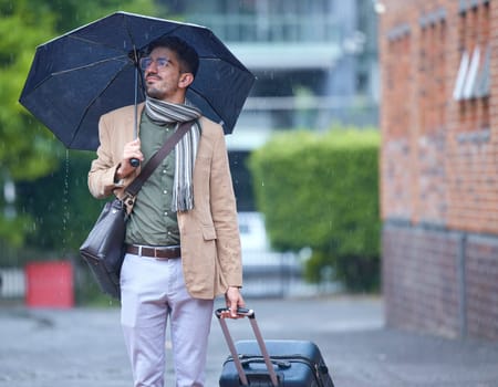 Thinking, travel and a man with an umbrella and suitcase in the rain in the morning. Serious, winter and a person with luggage for a vacation, immigration or holiday in the city for commute ideas