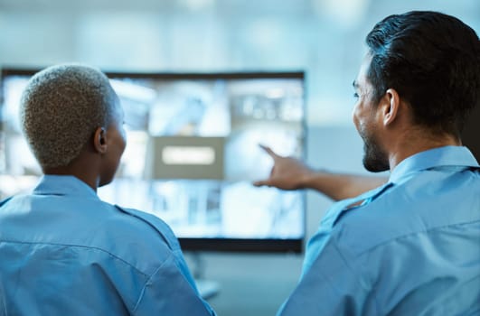 Safety, security guard team and control room with a computer screen for surveillance. Behind a woman and man pointing at cctv monitor for crime investigation, supervision and monitoring live camera