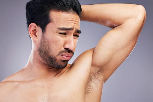 Armpit, smell and man with body odor in studio isolated on a white background for deodorant, cleaning and skincare cosmetic. Underarm, bad stink and model with hyperhidrosis, sweating or poor hygiene