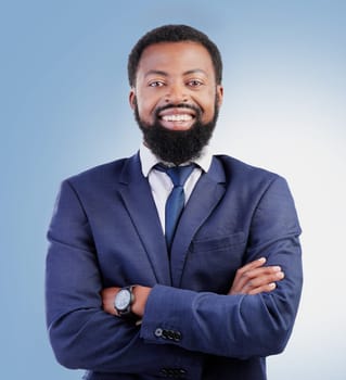 Happy, crossed arms and portrait of businessman in a studio with success, confidence and leadership. Smile, professional and headshot of a young, smart and African lawyer isolated by blue background.