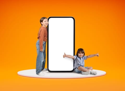 Cheerful kids boy and girl posing with big phone, mockup