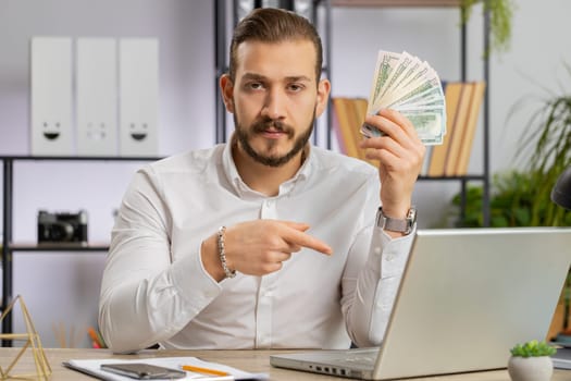 Young business man showing money dollar cash gives to you wages salary, satisfied with good work