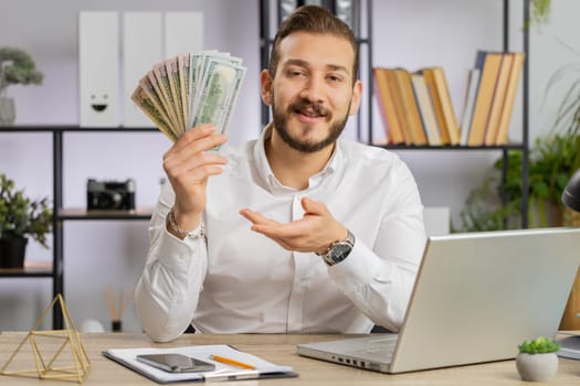 Young business man showing money dollar cash gives to you wages salary, satisfied with good work