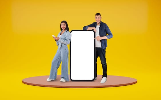 Happy international couple standing by huge phone, blank space