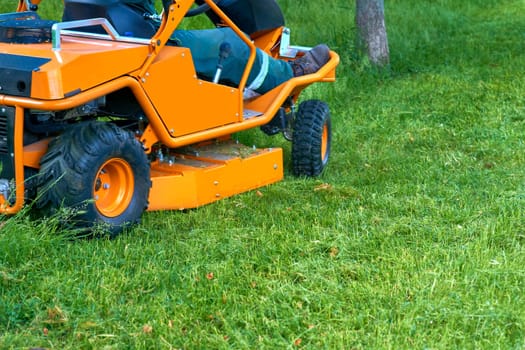 Professional grass cutting on lawns with a mini tractor lawn mower.
