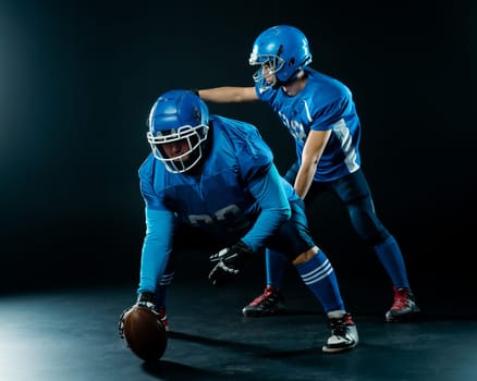 Two American football players are ready to start the game on a black background.