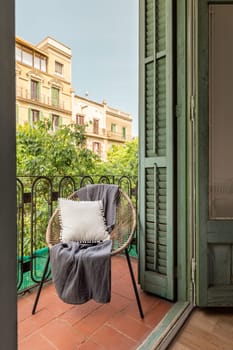Relaxing on a sunny balcony with traditional shutters and wooden chair