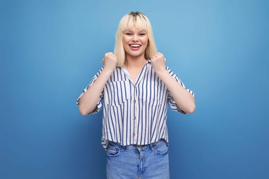 surprised blond caucasian 20s woman in striped shirt on studio background with copy space