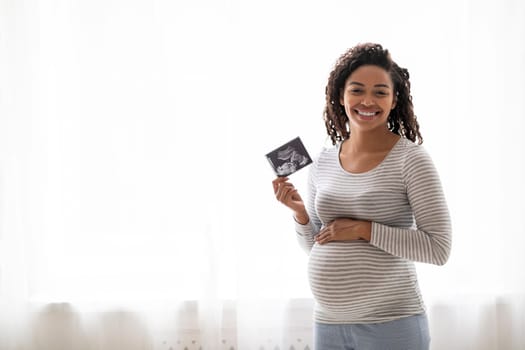 Maternity Concept. Happy Black Pregnant Lady Holding Ultrasound Photo Of Her Baby
