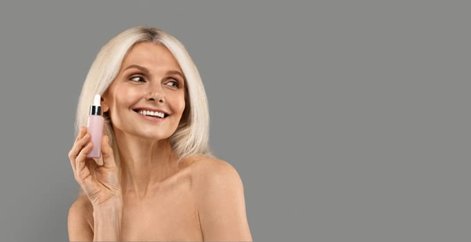 Anti-Aging Cosmetics. Beautiful Mature Woman Holding Bottle With Face Serum