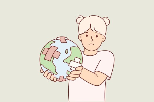 Little girl holding globe with band-aid, worrying about ECO issues and co2 carbon dioxide emissions