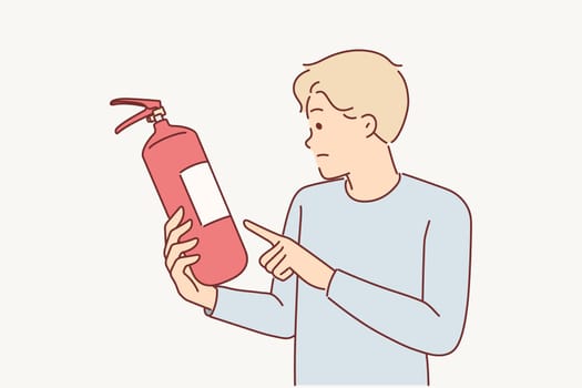 Man holds fire extinguisher checking expiration date equipment for extinguishing flame in emergency