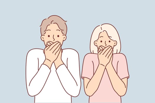 Frightened couple covers their mouths after seeing unexpected incident and looks at screen