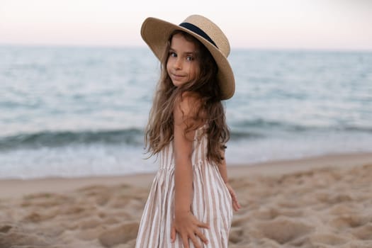 a baby girl in her sun hat on the beach