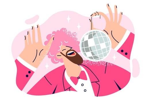 Dancing man with pink wig on head is holding disco ball and enjoying discotheque or music party