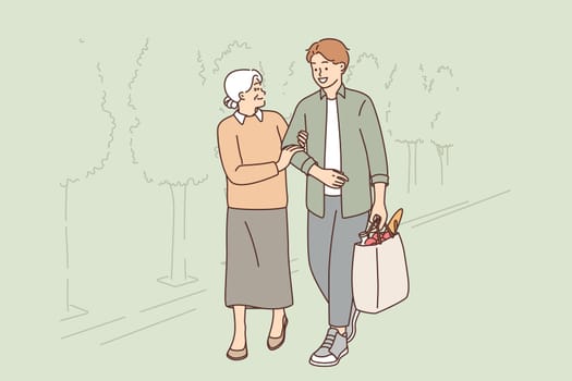 Young man helps old woman to carry heavy bag from grocery store, for concept respect for pensioners