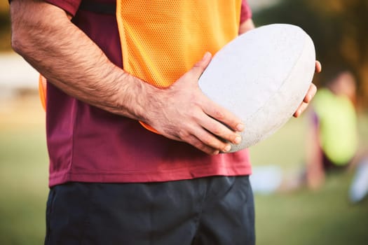 Rugby, man and hands with ball for outdoor games, competition and contest on field. Closeup of athlete, sports player and match at stadium for fitness, exercise and performance challenge on pitch
