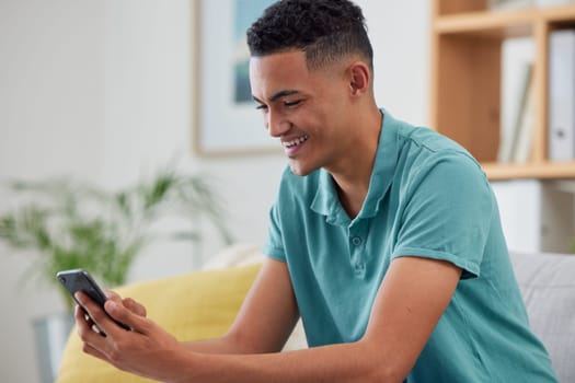 Young man, smartphone and chat, social media and communication with smile, website and internet scroll at home. Male person relax, using phone and connection, mobile app and contact with connectivity