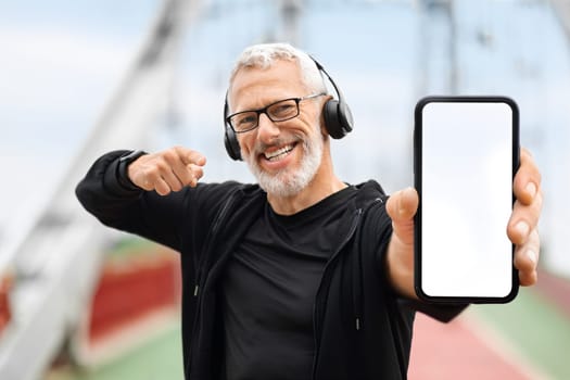 Retired sportsman showing phone with white empty screen, sports tech