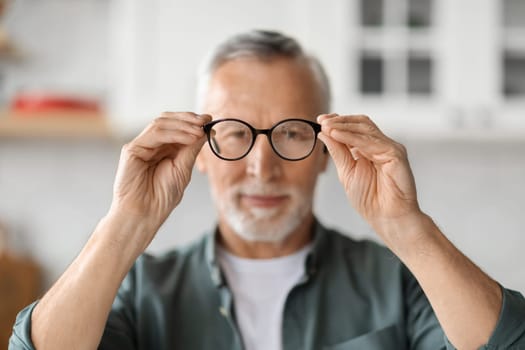 Eye Vision Concept. Senior Man Looking At Camera Through Eyeglasses In His Hands