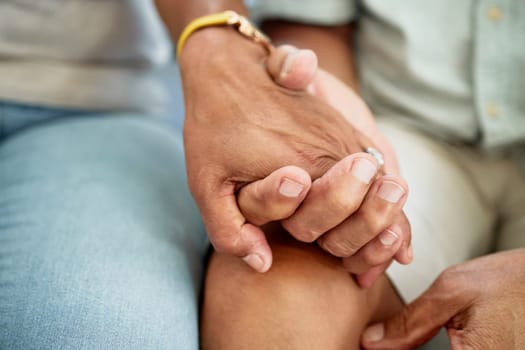 Love, support and couple holding hands for bonding, unity and connection in the living room of their home. Empathy, closeup and people with affection moment for sympathy after loss, sadness or grief.