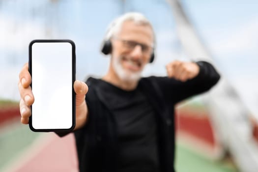 Phone with empty white screen in elderly sportsman hand