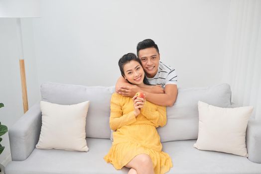 Newlywed couple sitting on a couch in a new living room