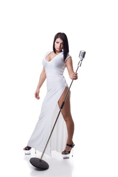 Sexy woman in long dress posing with microphone