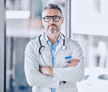 Mature doctor man, arms crossed and portrait for leadership in hospital, medical research or serious face for wellness. Professional medic, healthcare expert and clinic management job in Los Angeles