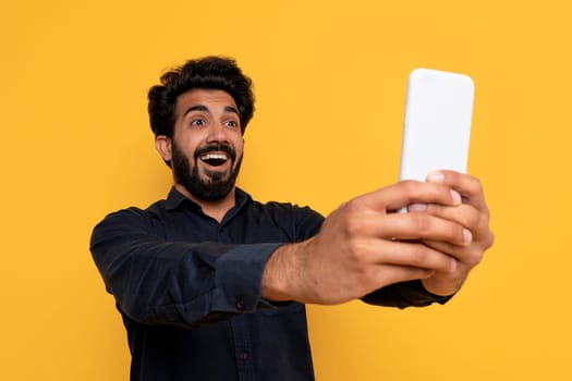 Portrait Of Surprised Indian Guy Looking At Smartphone Screen With Amazement
