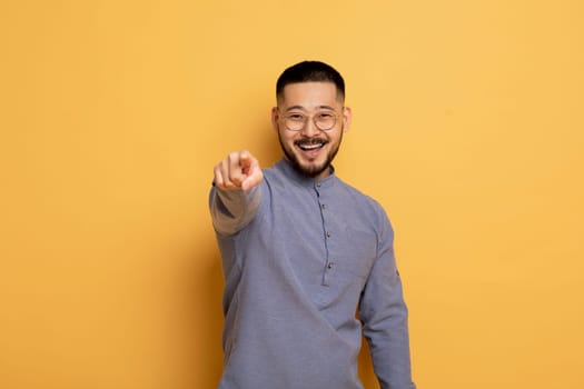 Portrait of young asian man pointing index finger at camera