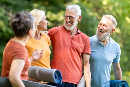 Happy Group Of Seniors Chatting Before Sport Training Outdoors, Cheerful Elderly Men And Women Holding Fitness Mats In Hands, Talking And Laughing, Mature Friends Enjoying Outside Workout, Closeup