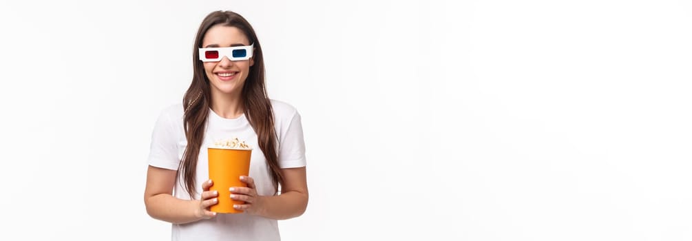 Entertainment, fun and holidays concept. Portrait of happy, joyful young girl enjoying watching awesome movie, premier night, wearing 3d glasses, smiling, eating popcorn, attend cinema.