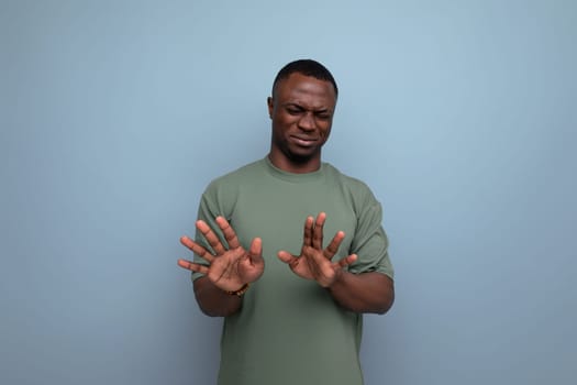 young handsome african man dressed in t-shirt shows denial and disagreement with hands