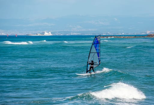 Enjoying extreme windsurfing and ocean waves on a hot sunny day. water sports concept