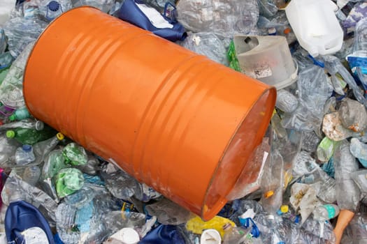 Orange barrel in a plastic garbage dump