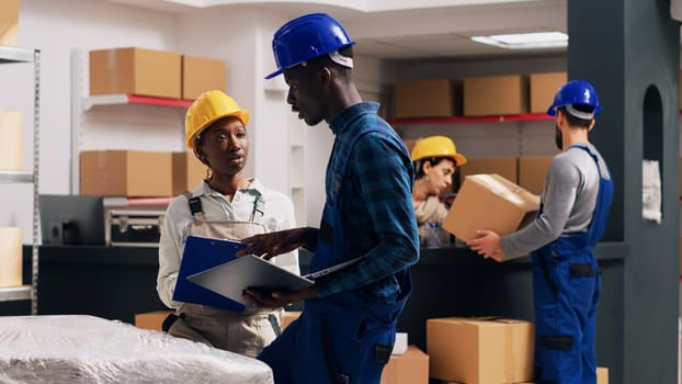 African american people doing quality control in warehouse