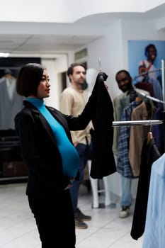 Pregnant customer examining apparel