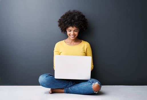 Remote work, online and black woman with laptop in studio with happiness for education or class. Computer, research and college student typing on keyboard for elearning, project or studying in home