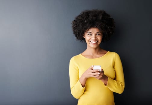 Social media, chat and portrait of black woman using phone or smile in studio, mockup and grey background. Cellphone, app or person typing contact or internet communication on website with happiness