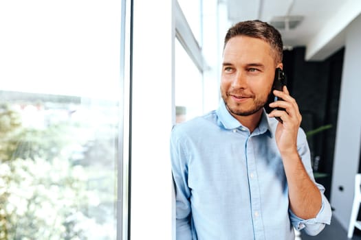 Handsome businessman speaking on the phone in office