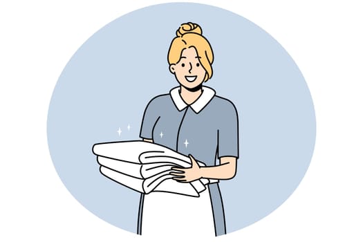 Smiling housekeeper with stack of towels