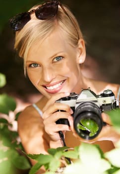Portrait, photographer and nature with woman in forest for trees, environment and relax. Shooting, camera lens and photography with face of female person in woods for travel, torusim and summer