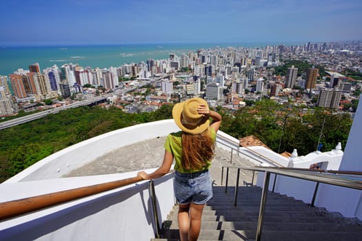 Tourism in Brazil. Rear view of beautiful fashion girl enjoying view of the Vitoria metropolitan region, Espirito Santo, Brazil.